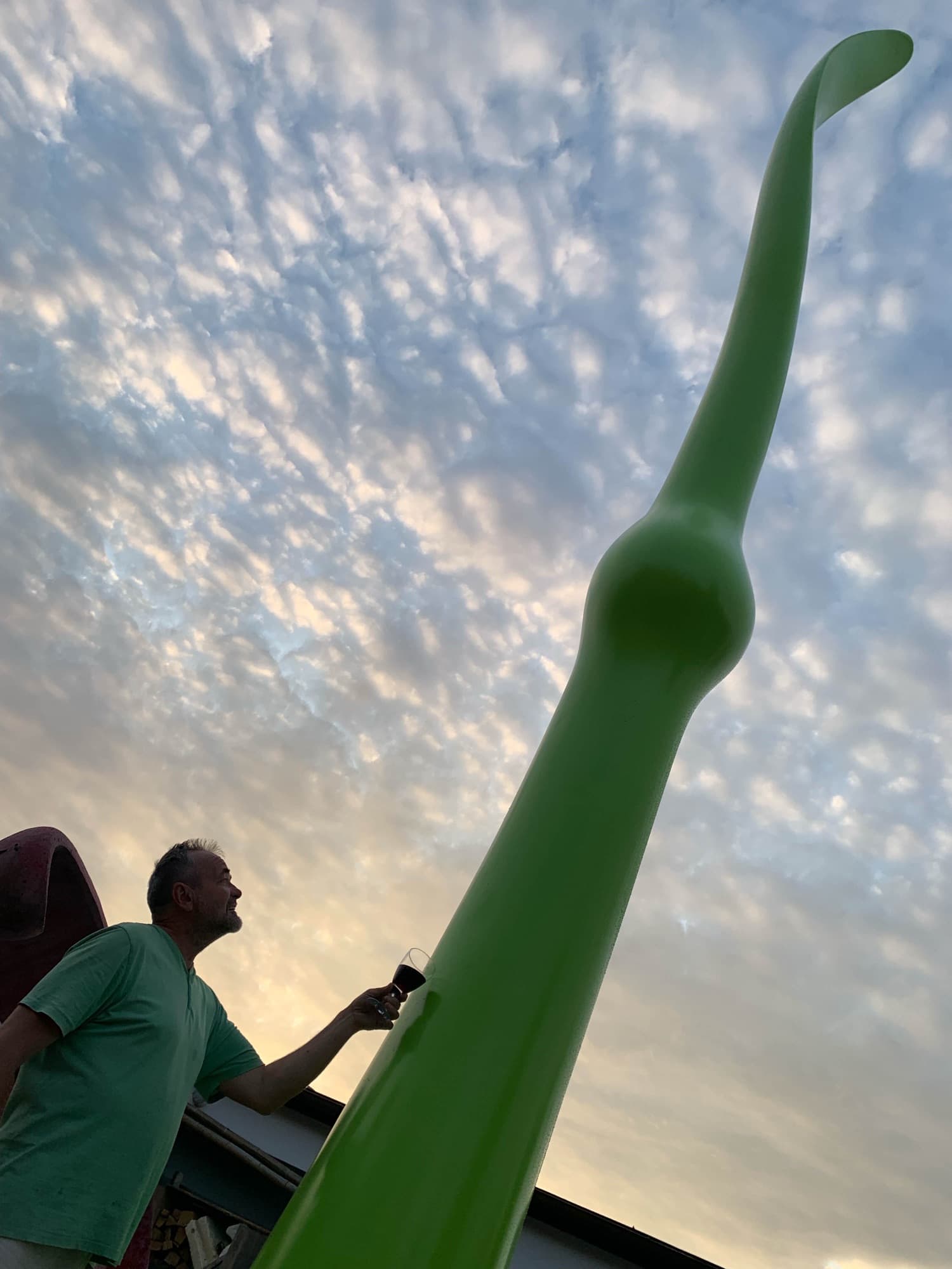 Green Life seen from below with a man touching the stem