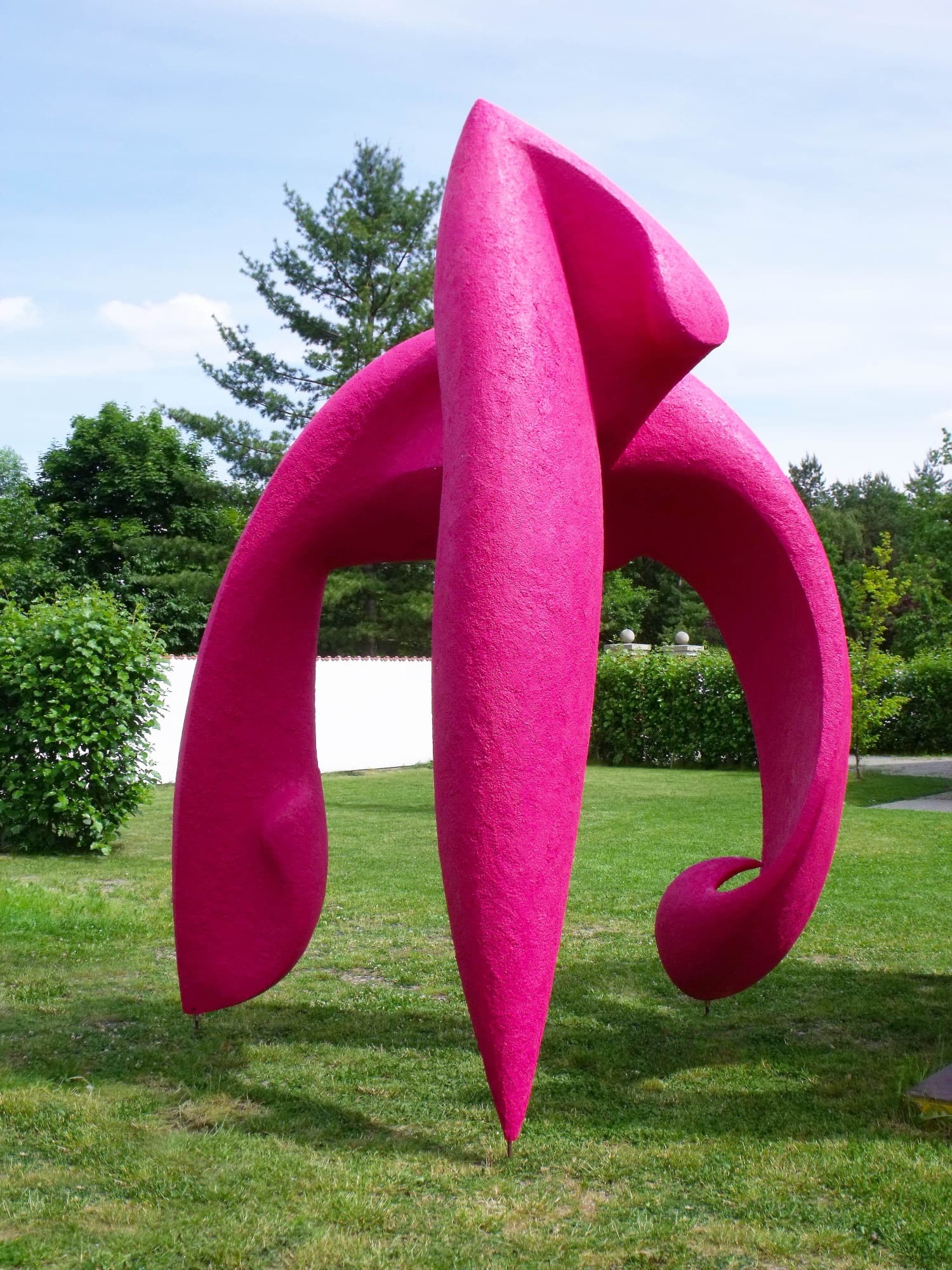Marilyn, large magenta abstract form standing on a garden lawn