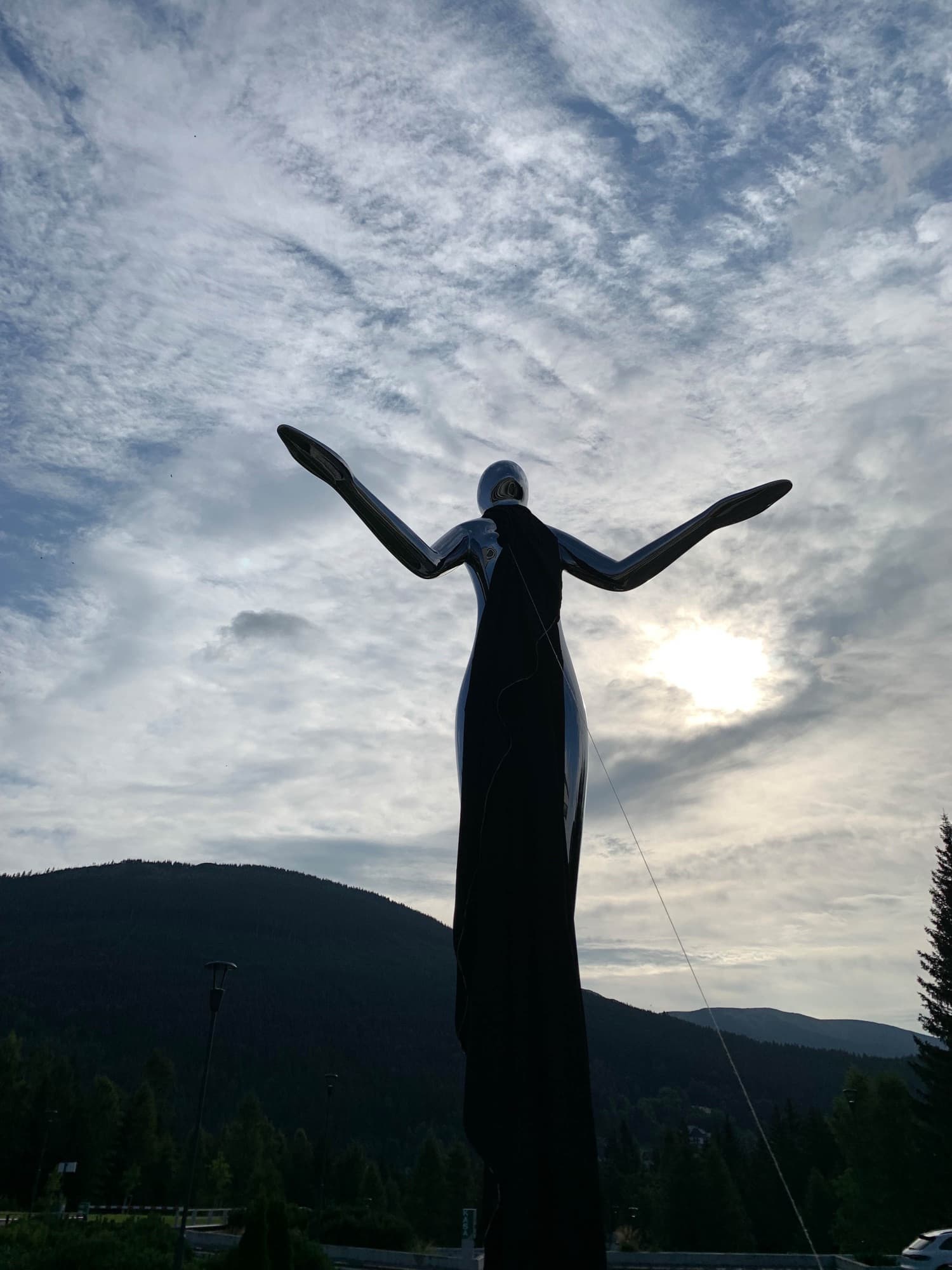 Harmony silhouetted against an overcast sky and mountains