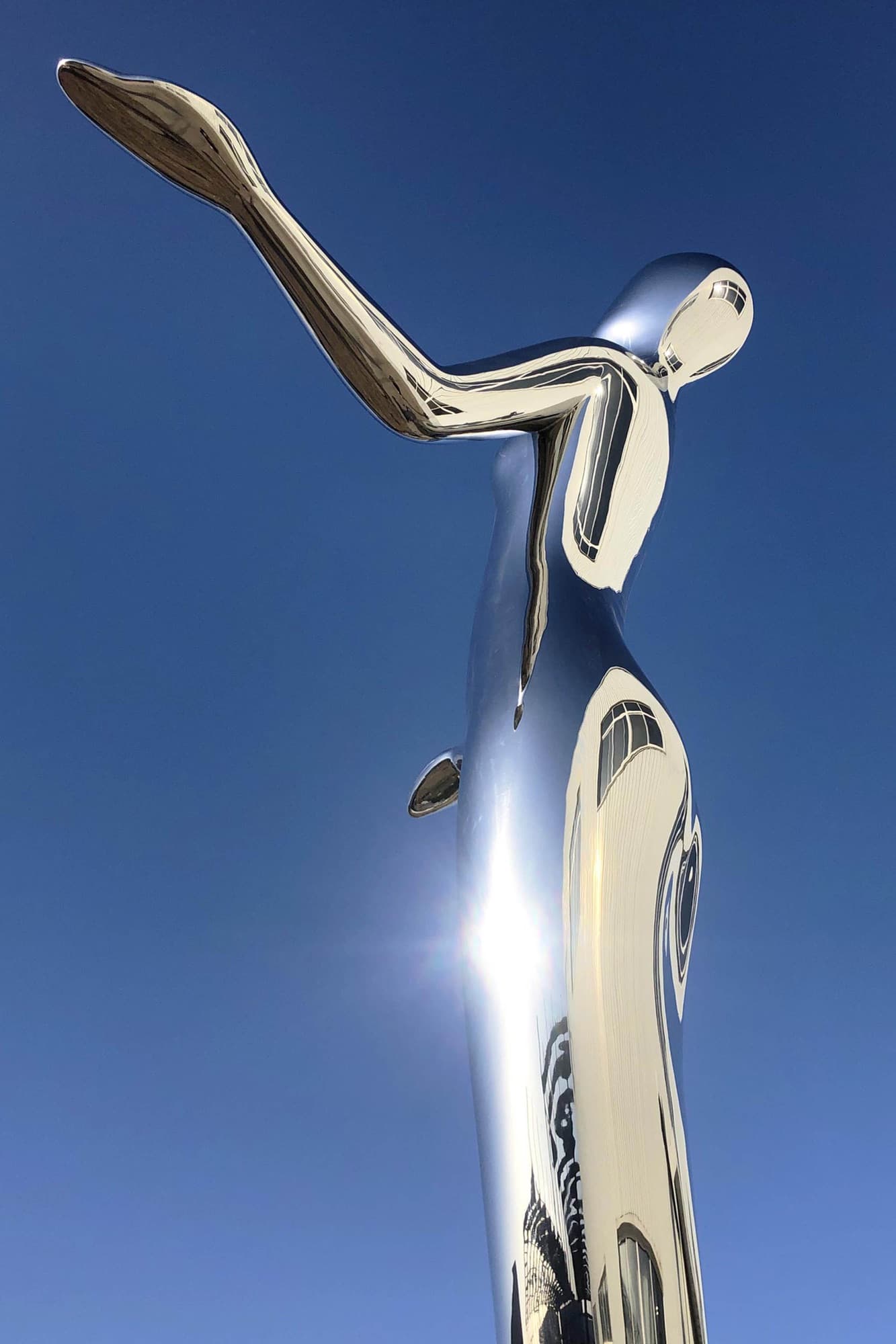 Harmony, low-angle view of the raised arm against a blue sky